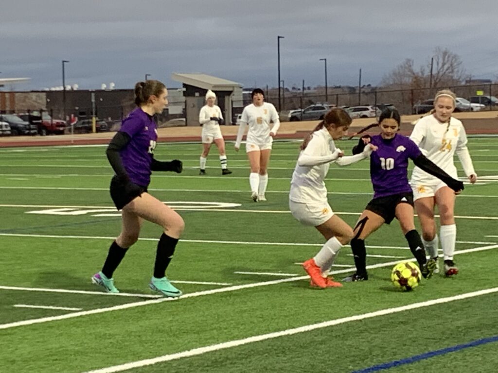 LHS and TJHS battle for ball at first girls soccer game.