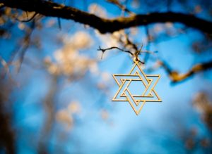 A Star of David hangs from a branch on a tree