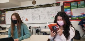Two students sit side-by-side in class