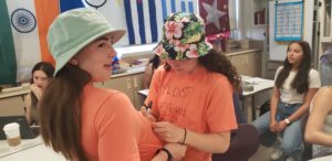 Two students sharpie one another's shirts to look the same