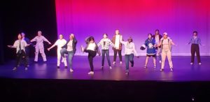 Choir members dance onstage