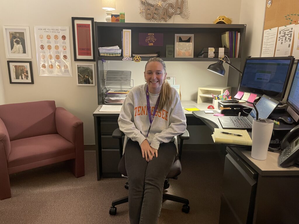 Ms.Beach sitting Infront of her desk in her counselling office.