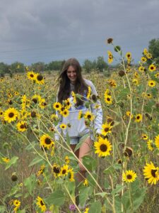 Sydney walks through a field of sunflowers